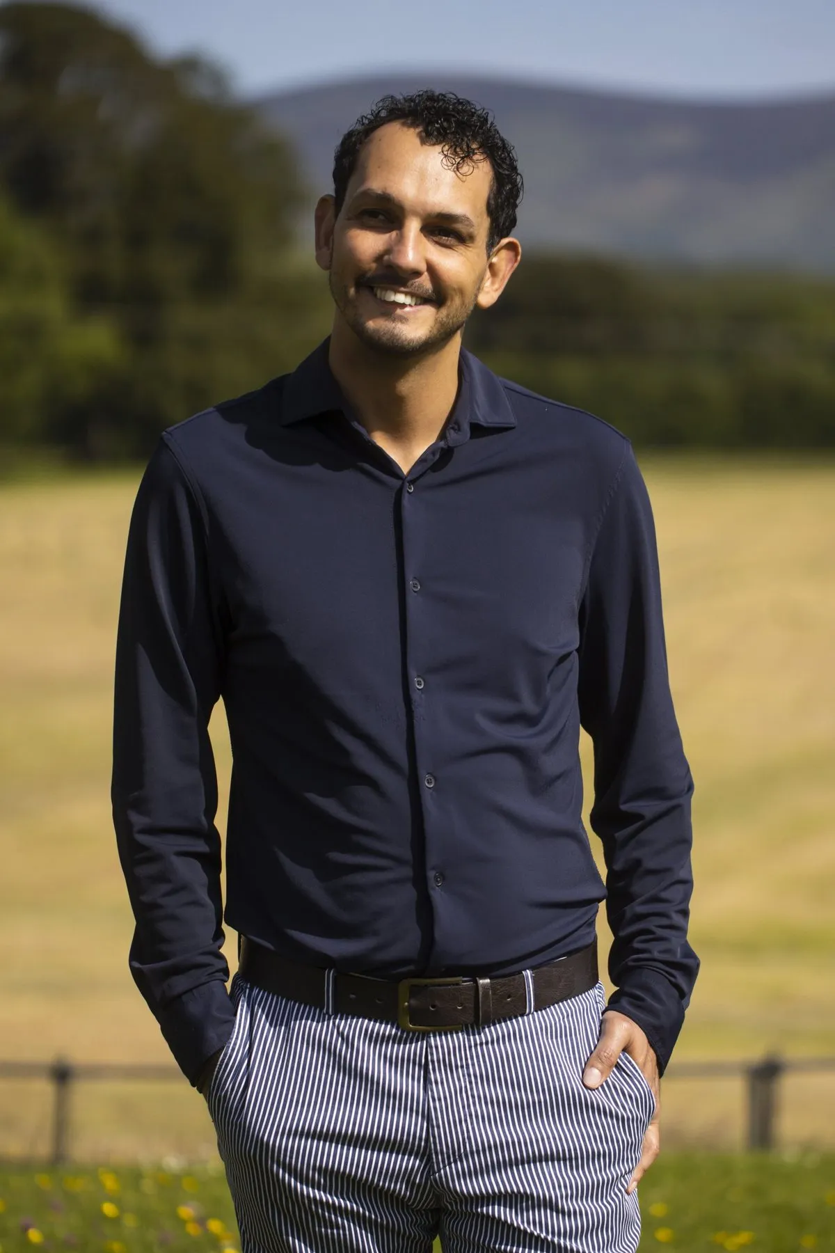 Daniel Pereira standing outdoors with his hands in his pockets, smiling.
